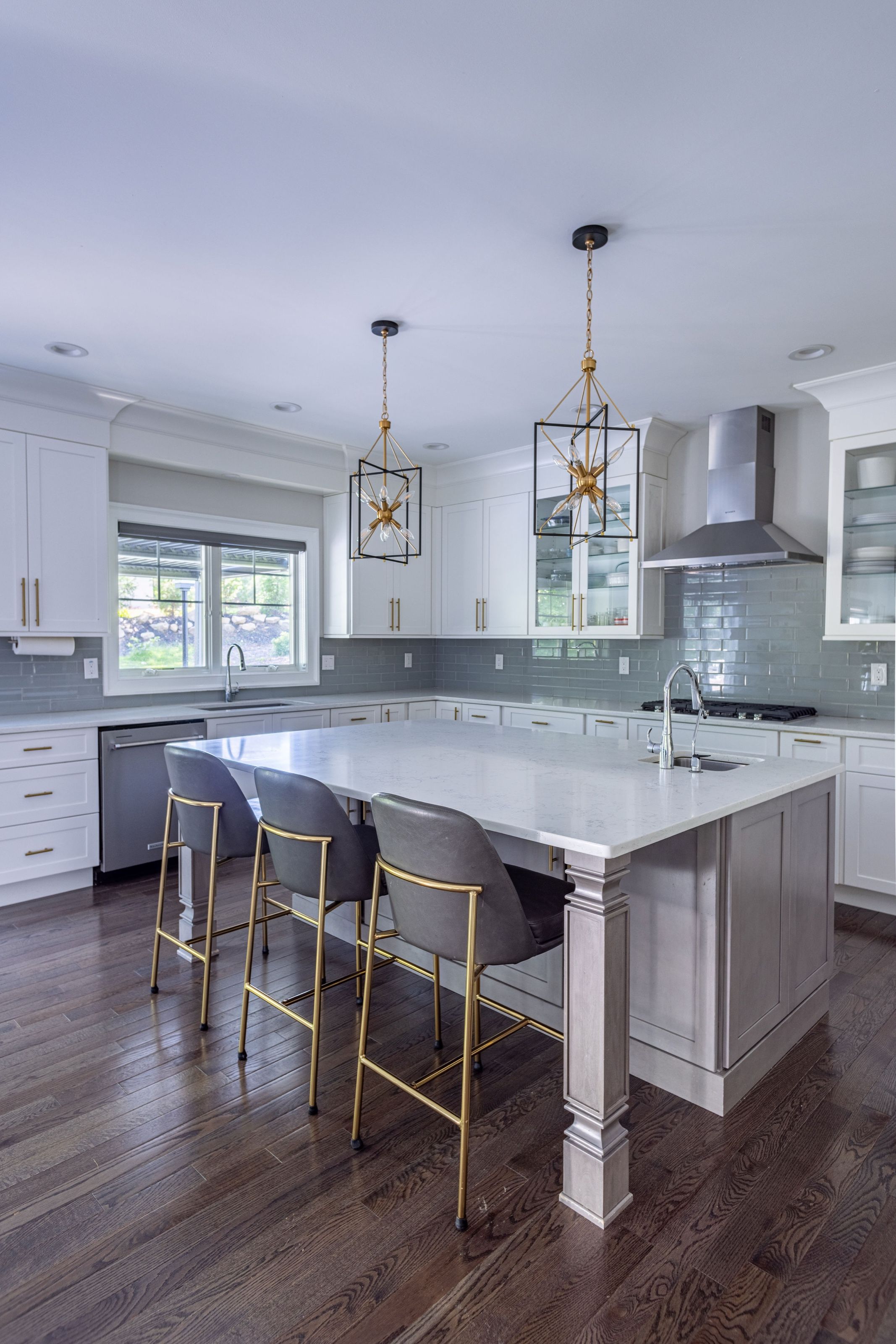 Kitchen island with counter stools and brass-and-glass lantern pendants overhead.