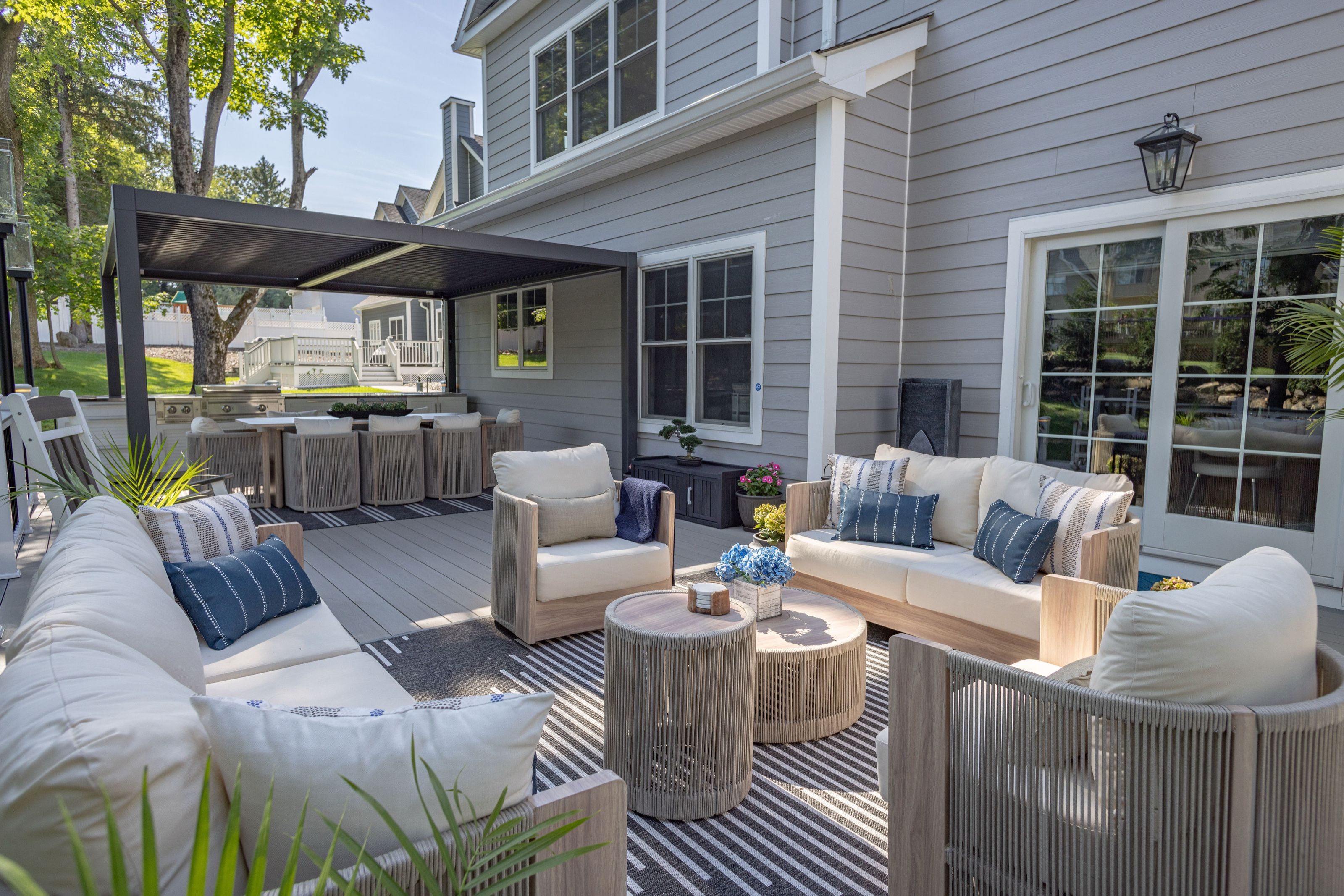 Outdoor deck with lounge seating and a covered kitchen and dining area beyond.
