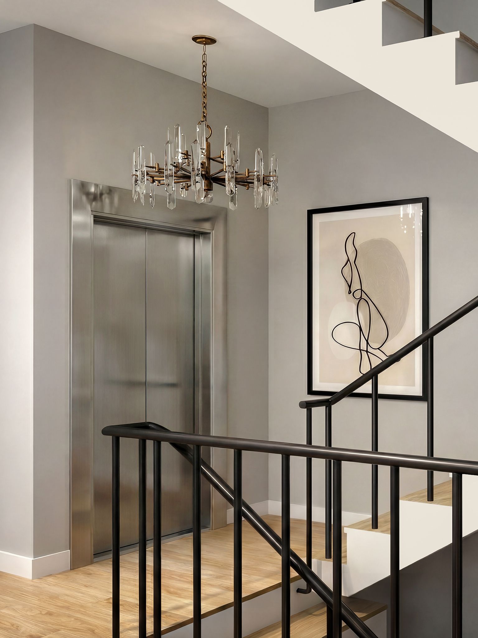 Contemporary stairwell with a stainless steel elevator, sculptural glass chandelier, black iron railing, and framed abstract artwork.