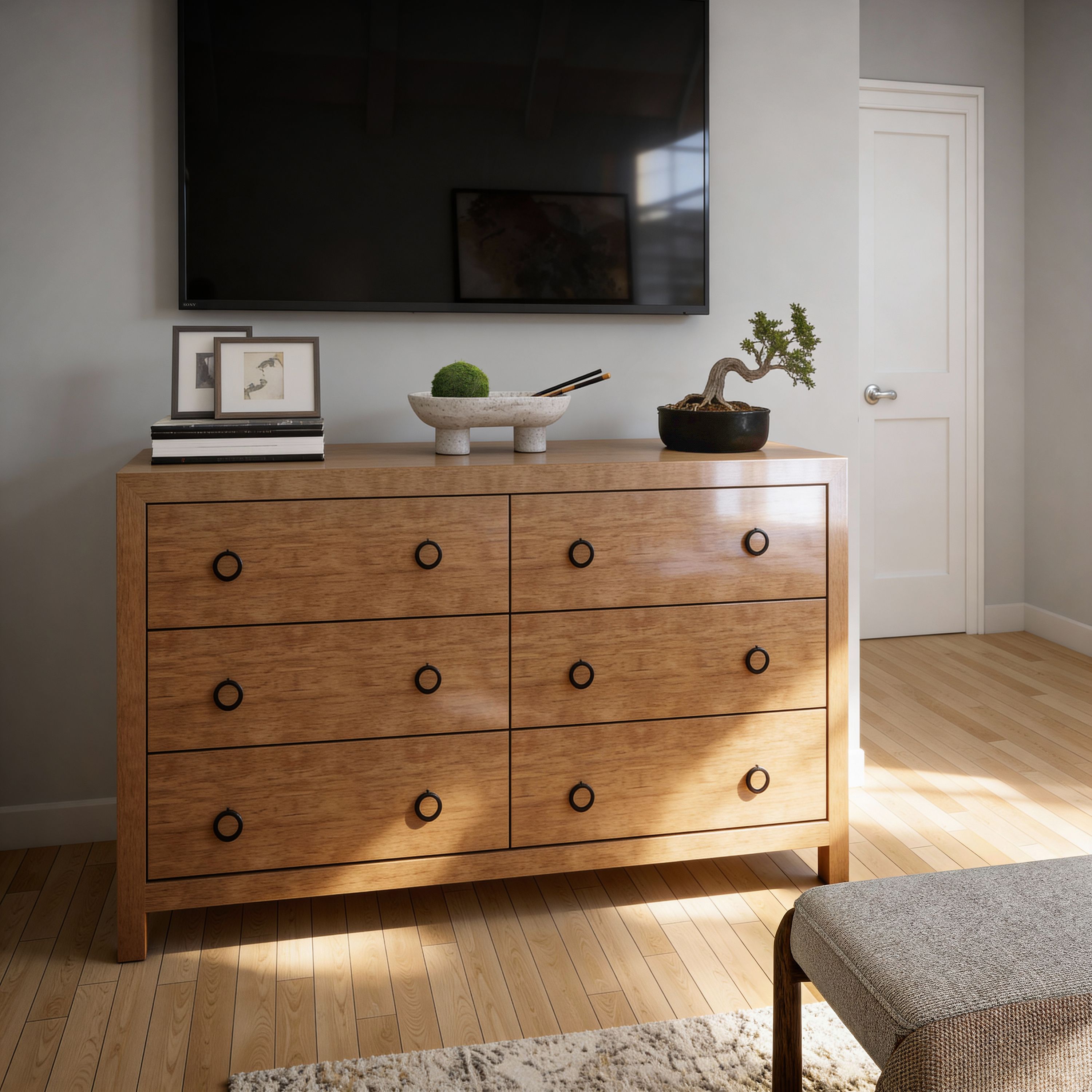 Bedroom with a wood dresser beneath a wall-mounted television.