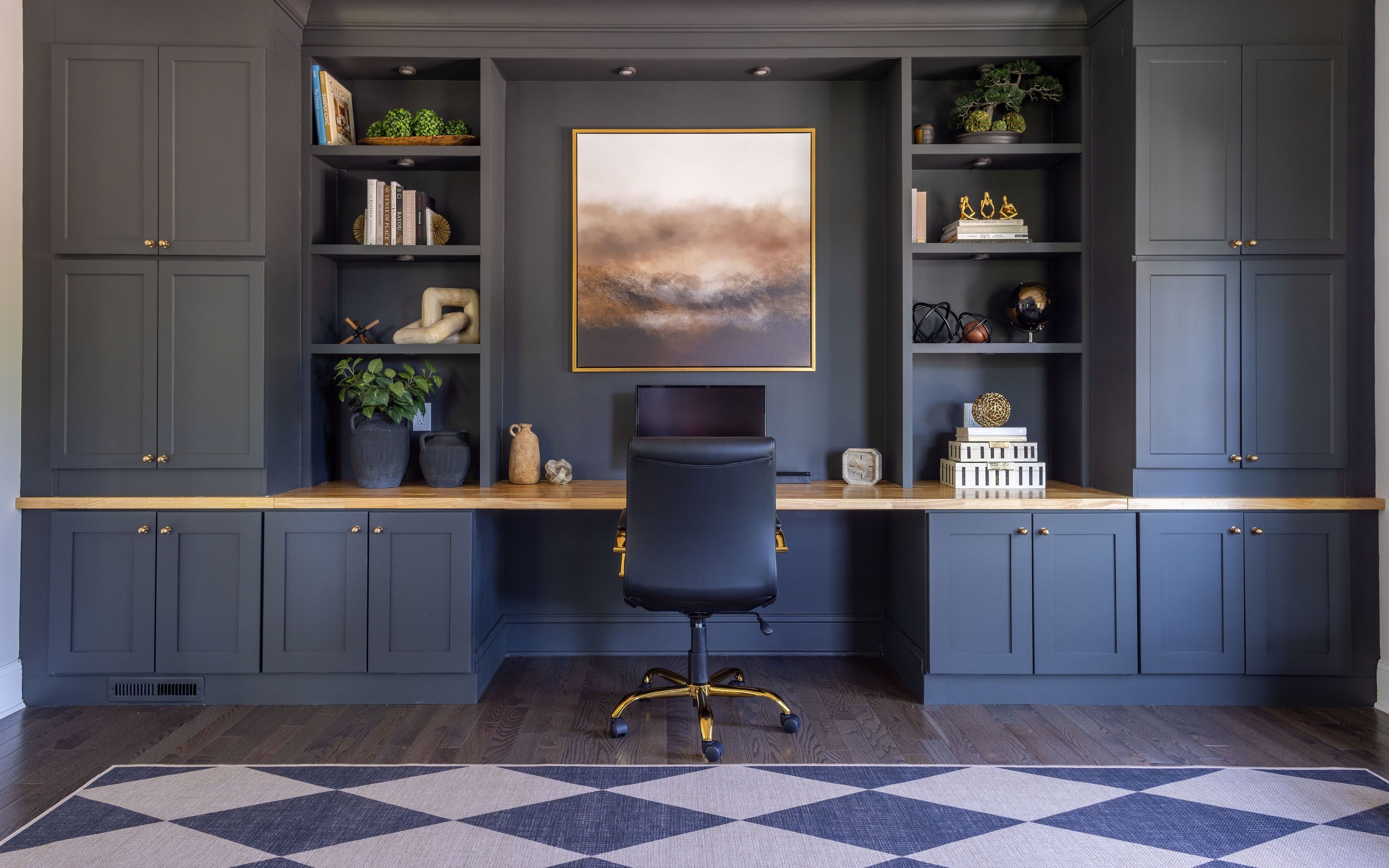 Home office with custom charcoal millwork, built-in cabinetry, a wood desktop, and framed abstract artwork in a Morris County, New Jersey home.