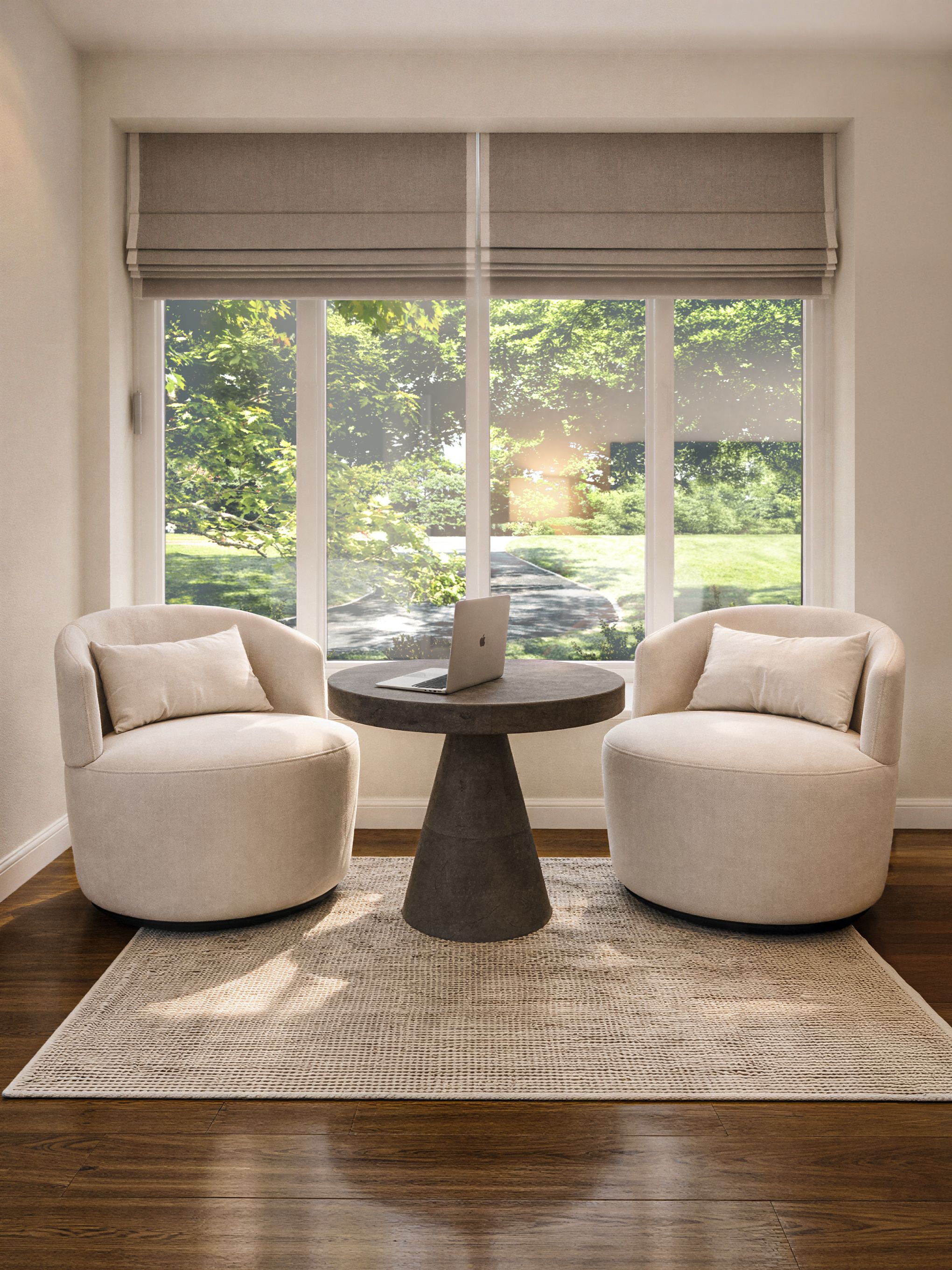 Sitting area with two swivel chairs, a round accent table, and custom window treatments framing a large window.