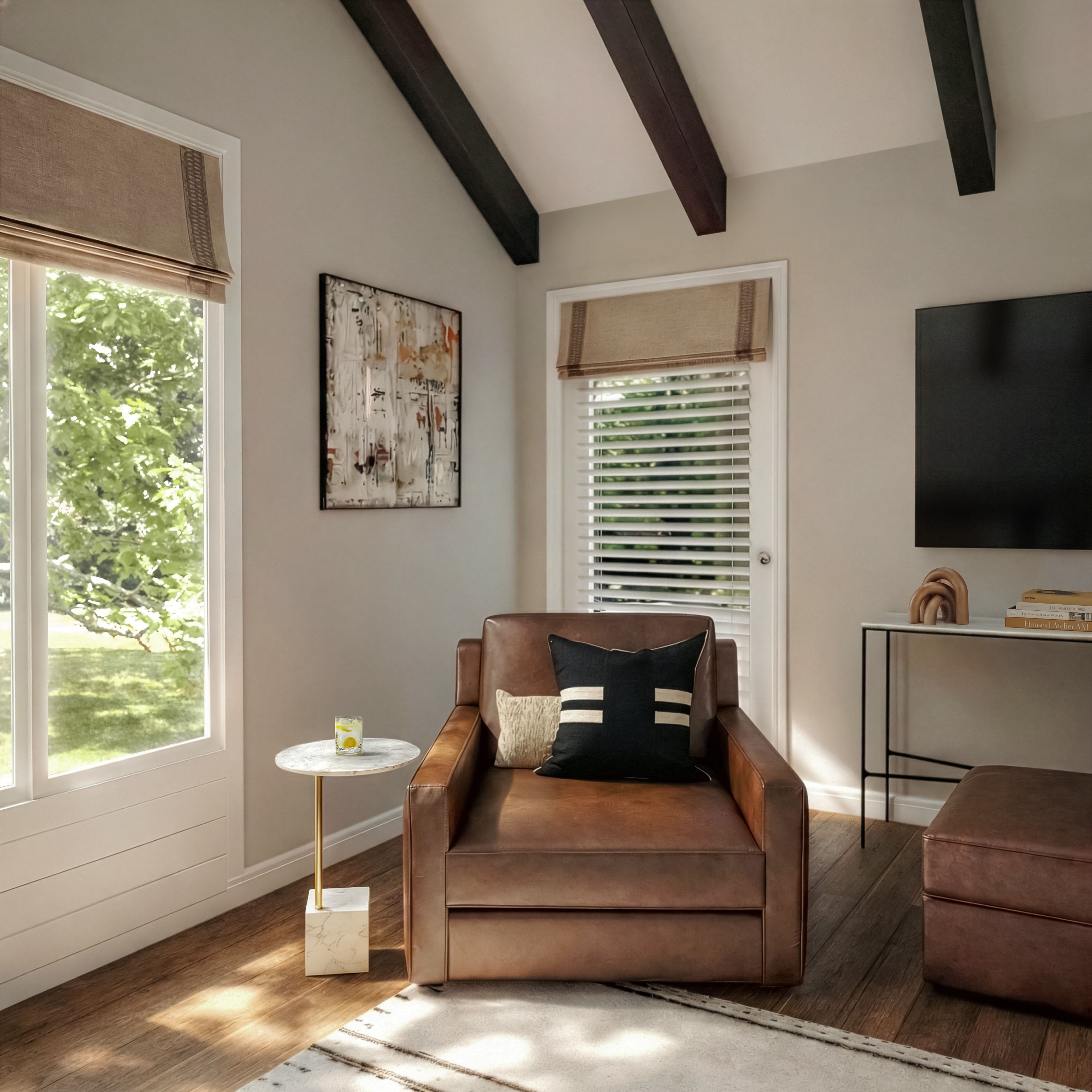 Bedroom sitting area with a leather armchair beside a window.
