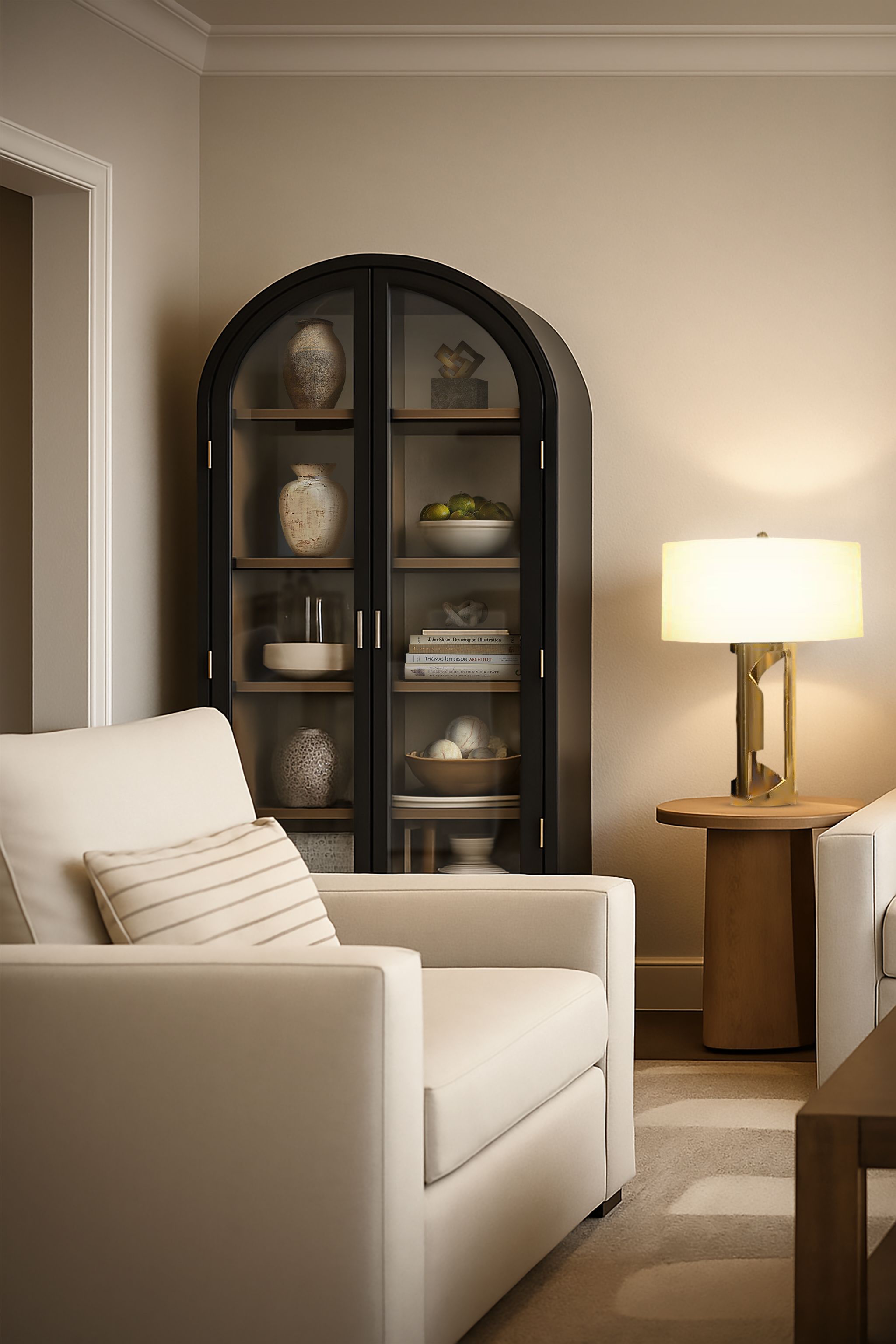 Living room corner with an upholstered armchair, arched glass cabinet, and brass table lamp.