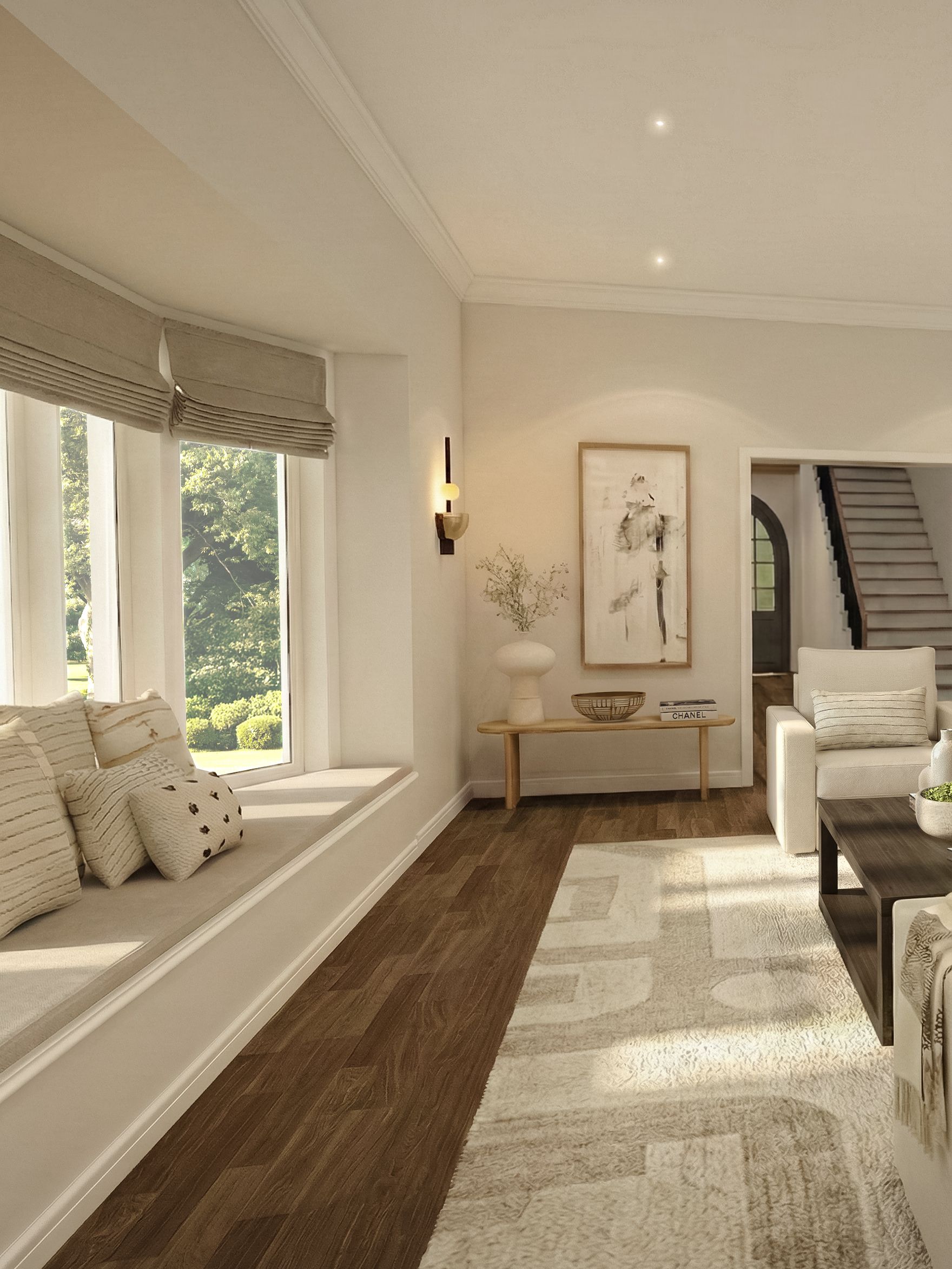 Living room with a cushioned bay window seat layered with textured throw pillows, leading toward a seating area with cream upholstery.
