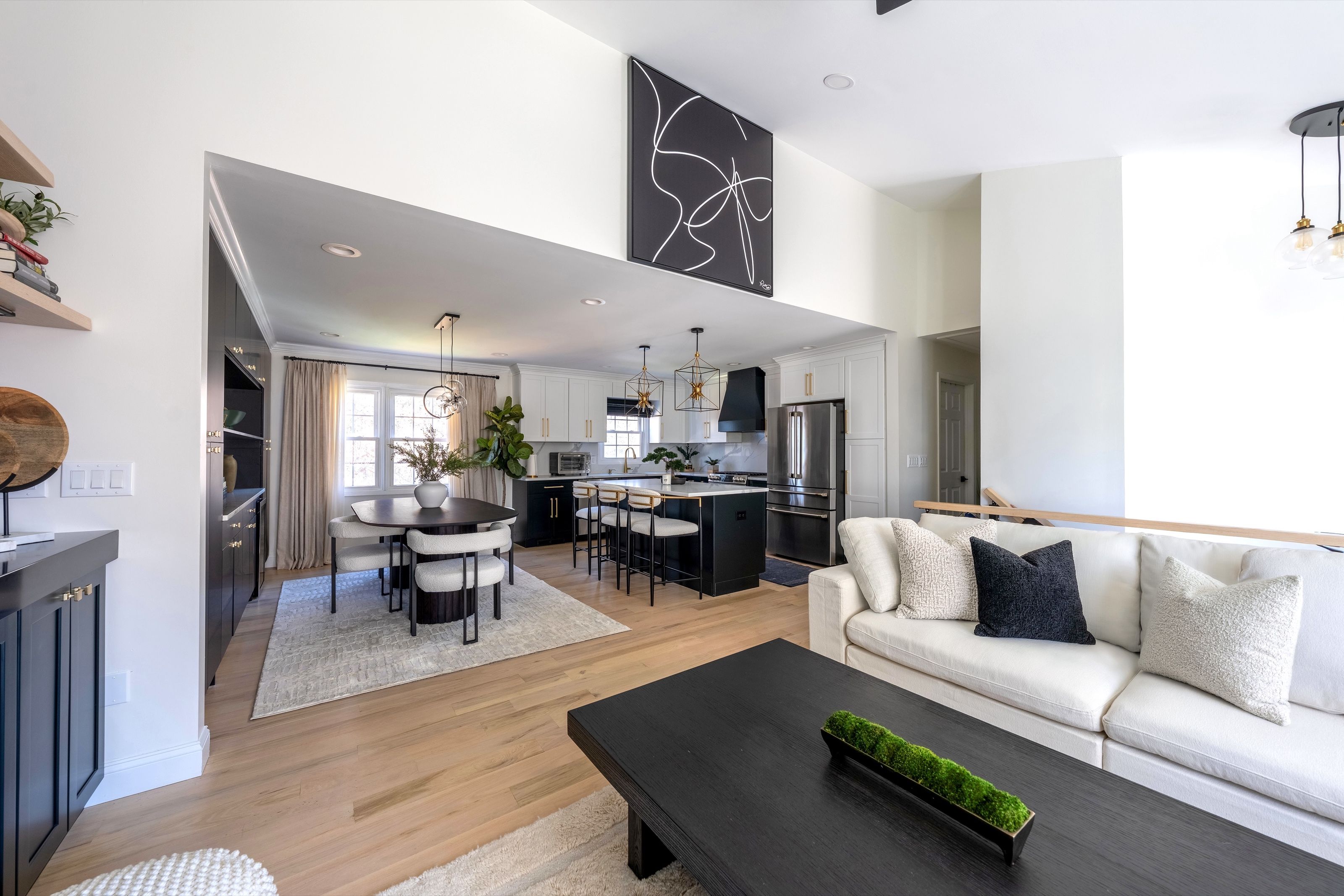 Open-concept living room overlooking the adjoining dining area and renovated kitchen, highlighting the connection between the spaces.