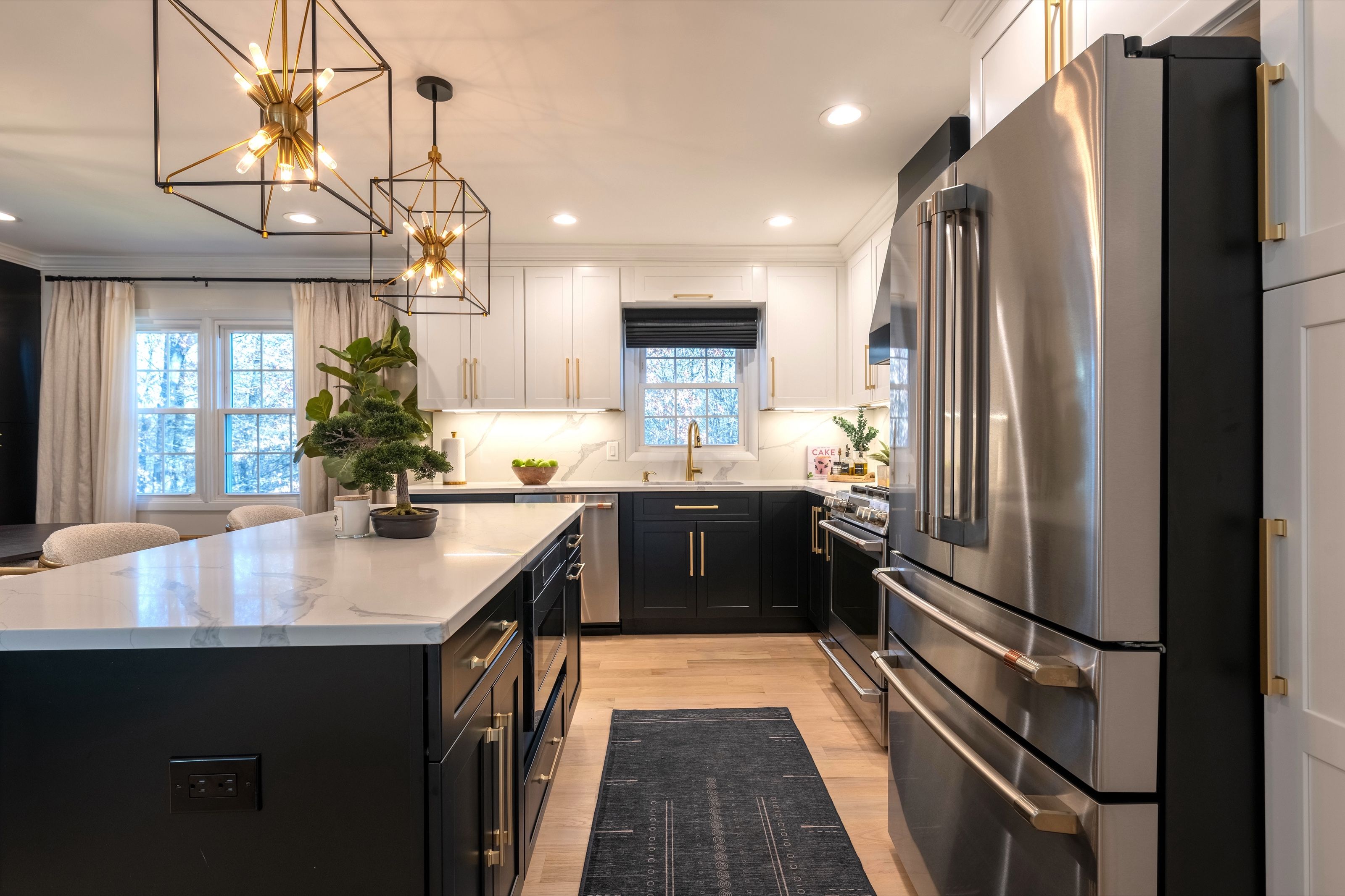 View along a renovated kitchen, showing the island, cooking range, and window beyond.